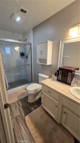 a bathroom with a double vanity sink a toilet a mirror and shower