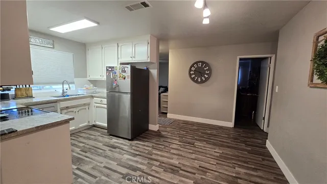 a kitchen with a refrigerator and a stove top oven