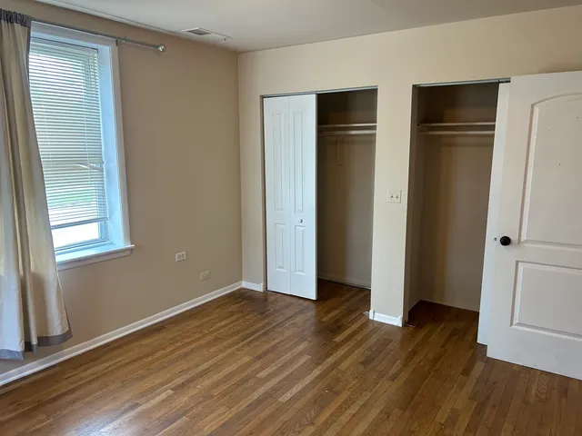 an empty room with wooden floor and closet