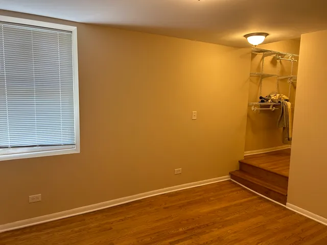 a view of a room with wooden floor and a window