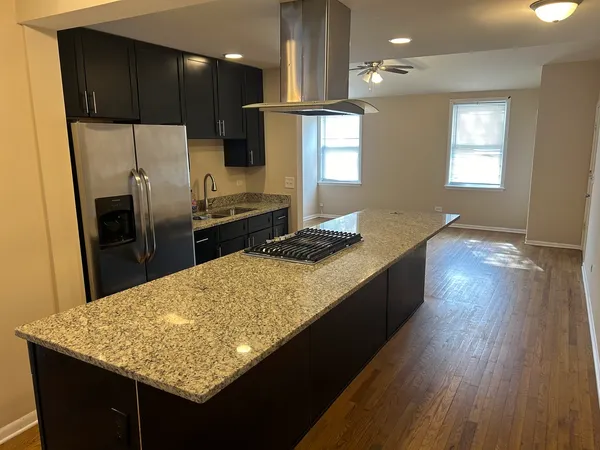 a kitchen with kitchen island granite countertop counter space a sink appliances and cabinets