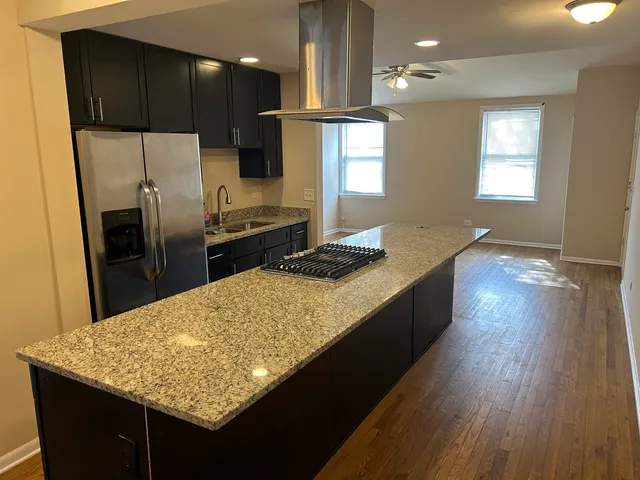 a kitchen with kitchen island granite countertop counter space a sink appliances and cabinets