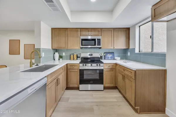 a kitchen with stainless steel appliances white cabinets a sink and a stove
