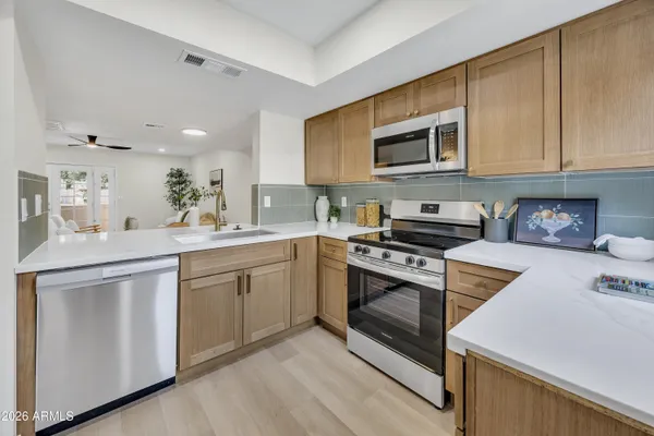 a kitchen with stainless steel appliances granite countertop a stove a sink and a microwave