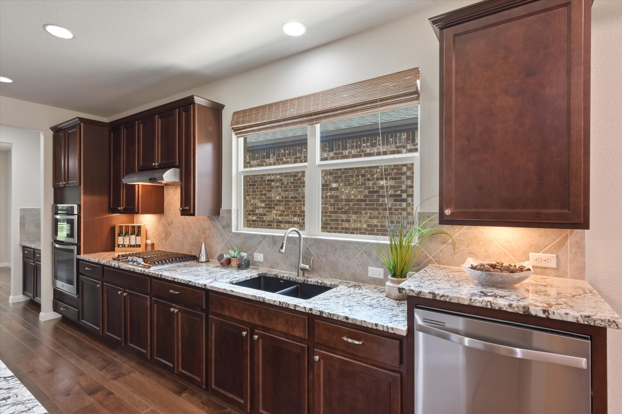 104 Coffee Mill Creek Road Georgetown, TX 78633 - Photo 9 of 40 A well-appointed kitchen features rich wood cabinetry, granite countertops, and modern stainless steel appliances.