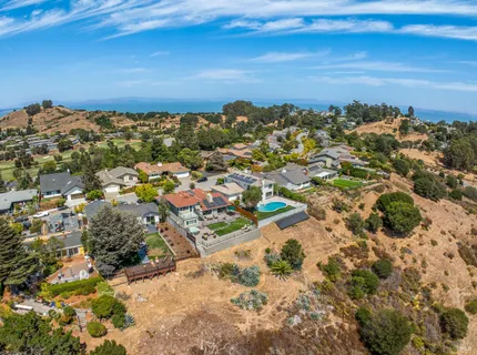 an aerial view of residential houses with outdoor space and river