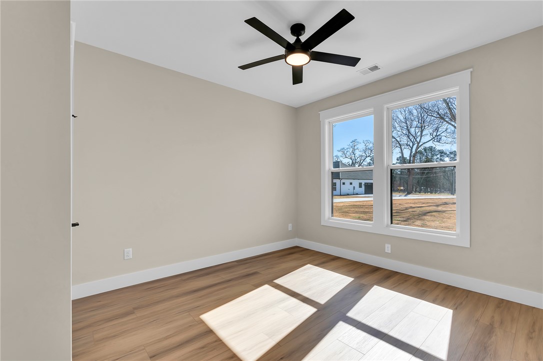 4546 Flat Rock Road Iva, SC 29655 - Photo 18 of 28 This spacious room features ample natural light and durable flooring, offering a versatile living space.