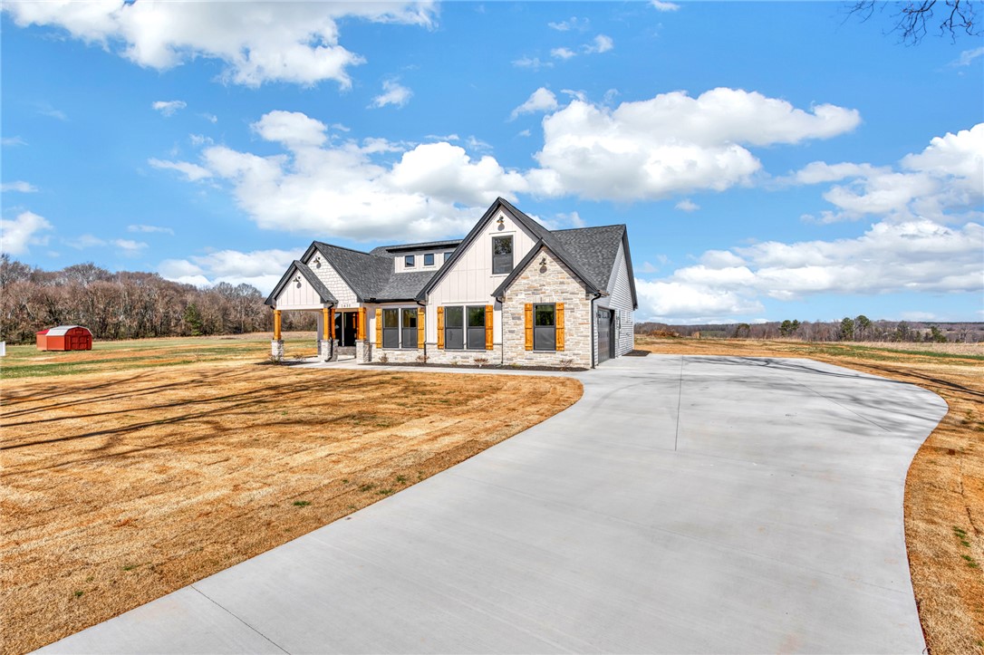 4546 Flat Rock Road Iva, SC 29655 - Photo 4 of 28 This newly constructed home boasts a beautiful stone and siding exterior with a large driveway.