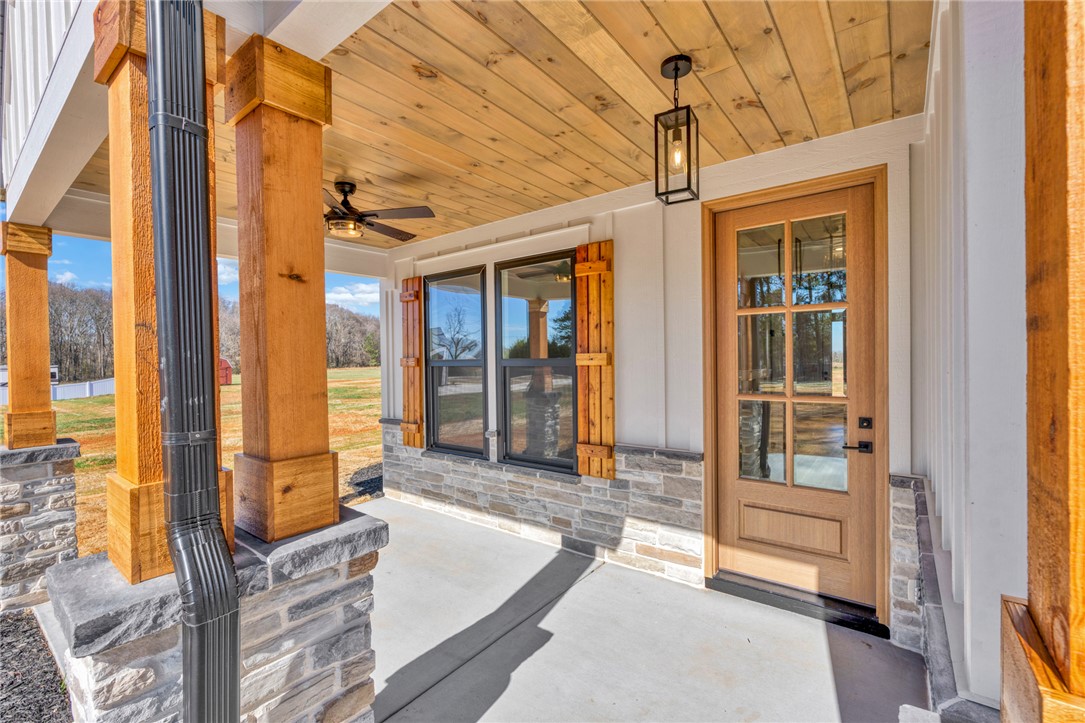 4546 Flat Rock Road Iva, SC 29655 - Photo 7 of 28 This inviting porch offers a warm welcome with its natural wood and stone accents.