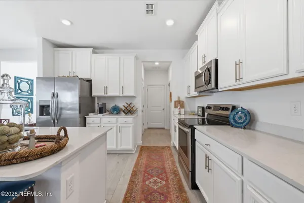 a kitchen with granite countertop white cabinets and white appliances