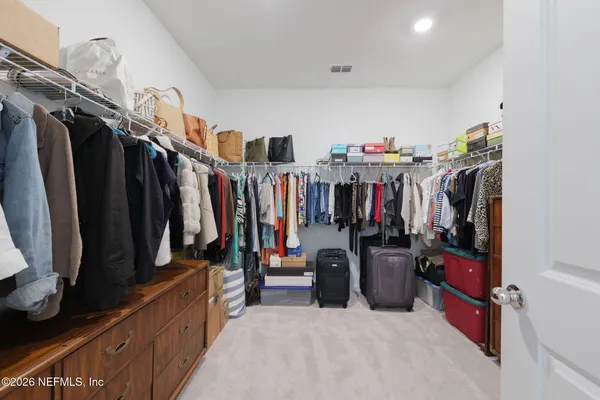 a view of walk in closet with clothes and shoes