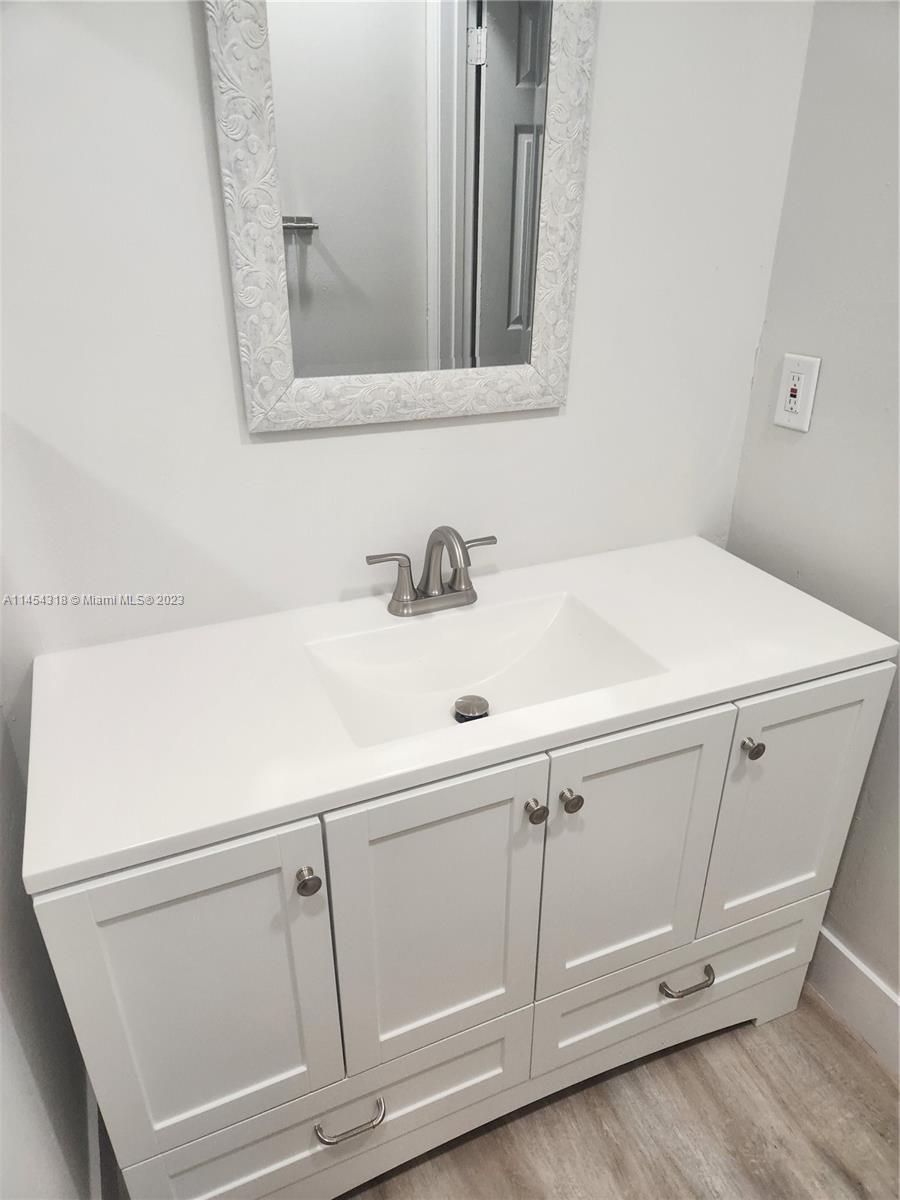 7753 Courtyard Run West, Unit 7753 Boca Raton, FL 33433 - Photo 13 of 15 a bathroom with a sink and a mirror