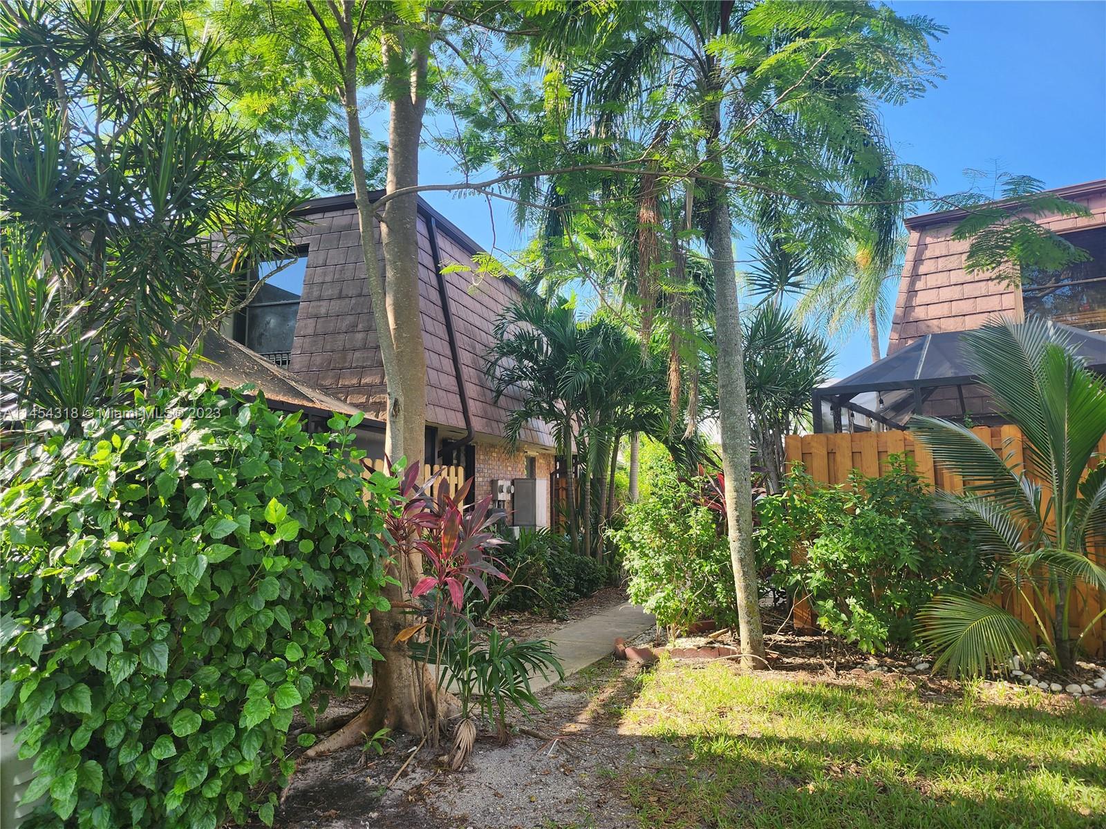7753 Courtyard Run West, Unit 7753 Boca Raton, FL 33433 - Photo 2 of 15 a view of a house with a tree and plants