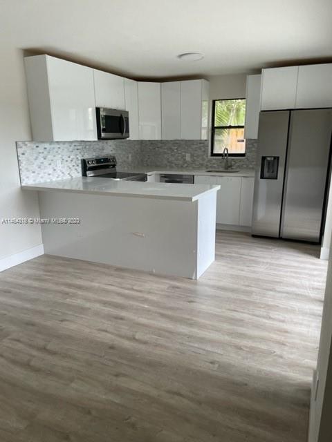 7753 Courtyard Run West, Unit 7753 Boca Raton, FL 33433 - Photo 5 of 15 a kitchen with stainless steel appliances a refrigerator microwave and sink