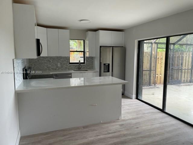 7753 Courtyard Run West, Unit 7753 Boca Raton, FL 33433 - Photo 6 of 15 a large kitchen with kitchen island a large counter top space a sink stainless steel appliances and cabinets
