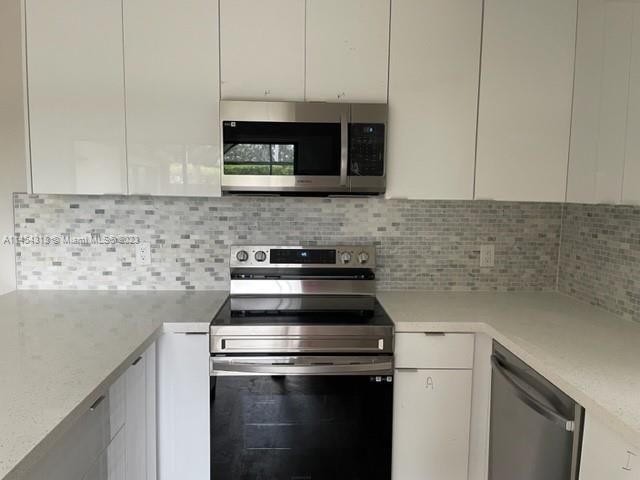 7753 Courtyard Run West, Unit 7753 Boca Raton, FL 33433 - Photo 7 of 15 a kitchen with a stove and a microwave