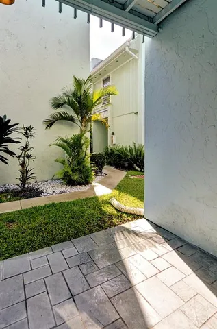 a view of a small yard with a bench and plants