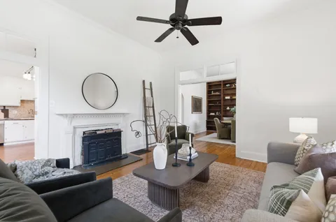 a living room with furniture a fireplace a rug and a large window
