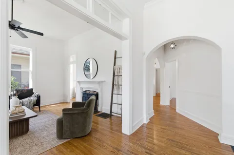 a living room with furniture a clock and wooden floor