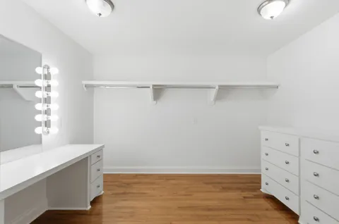 a view of an empty room with cabinet and mirror