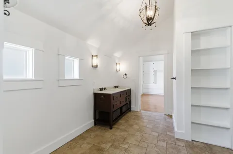 a large white kitchen with a stove a sink dishwasher and a refrigerator with wooden floor