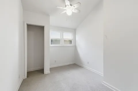 an empty room with a fan and a window