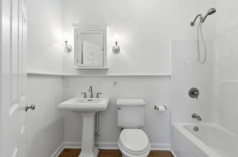 a bathroom with a sink mirror toilet and bathtub