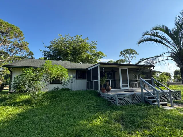 a view of a house with backyard sitting area and garden