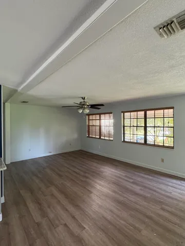 wooden floor in an empty room with a window