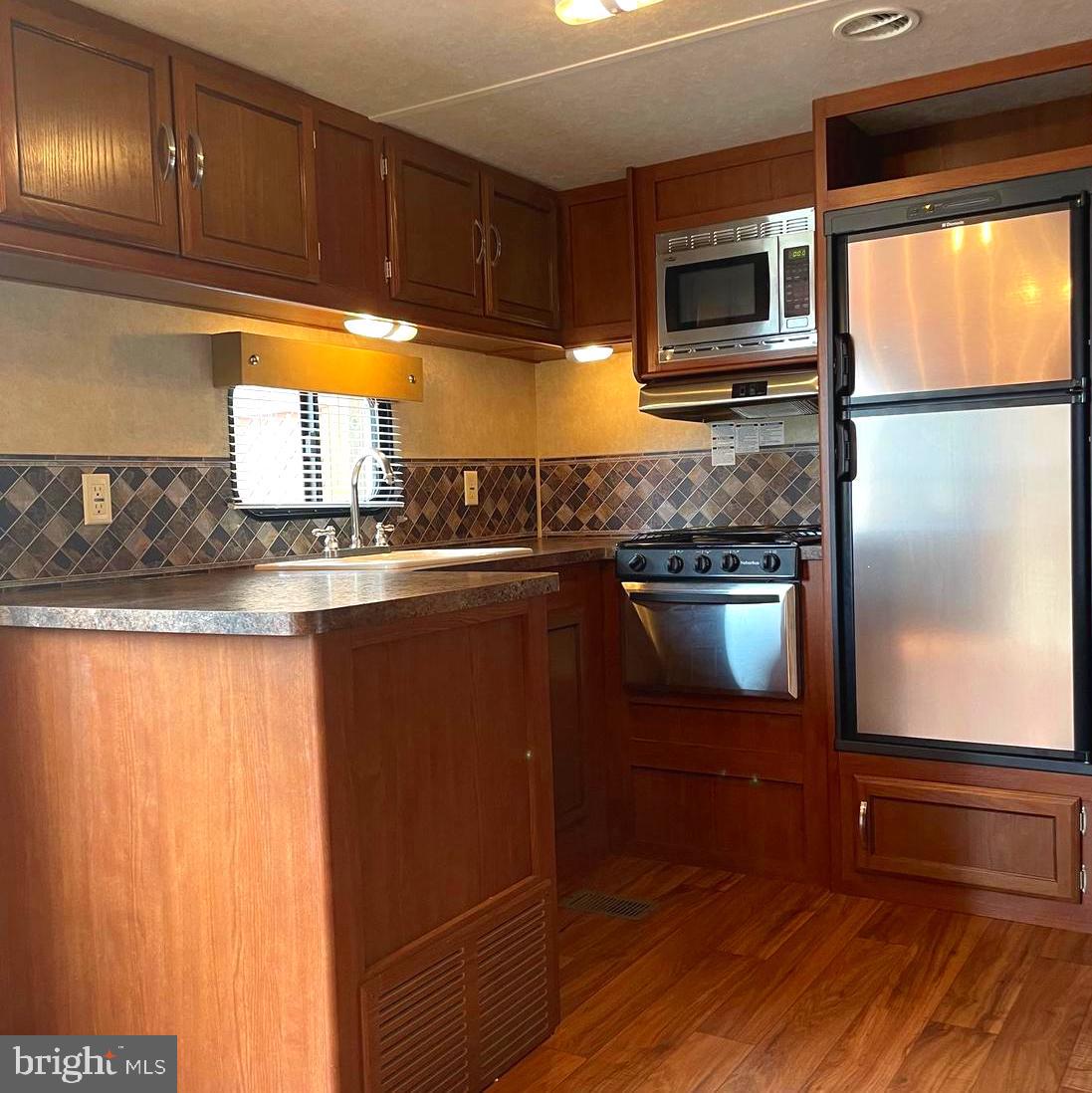 52 Block Butterfly Boulevard Falling Waters, WV 25419 - Photo 4 of 23 a kitchen with granite countertop stainless steel appliances and wooden cabinets