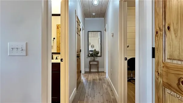 a view of a hallway with wooden floor and staircase