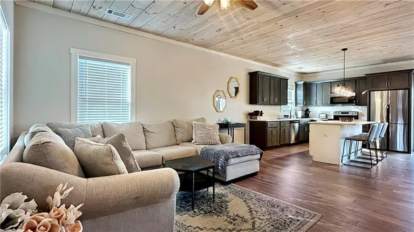 a living room with furniture kitchen view and a window