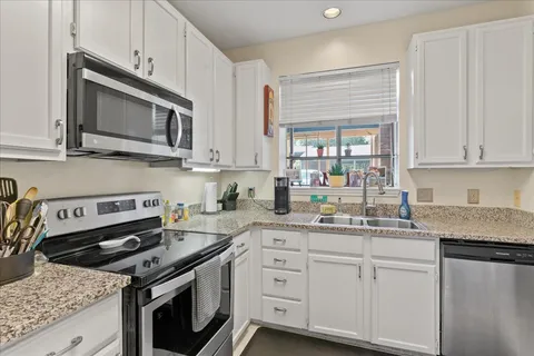 a kitchen with stainless steel appliances granite countertop a sink stove and microwave