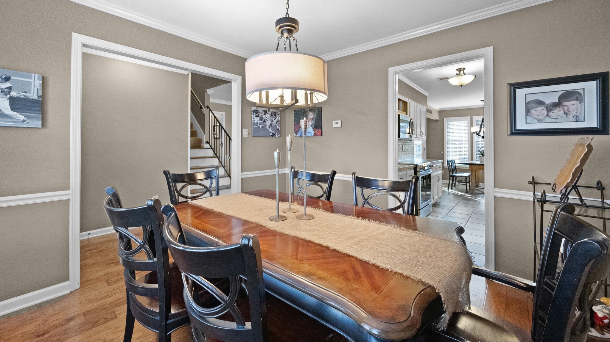 1883 Edwards Mill Road Germantown, TN 38139 - Photo 17 of 40 a dining room with wooden floor a chandelier a wooden table and chairs