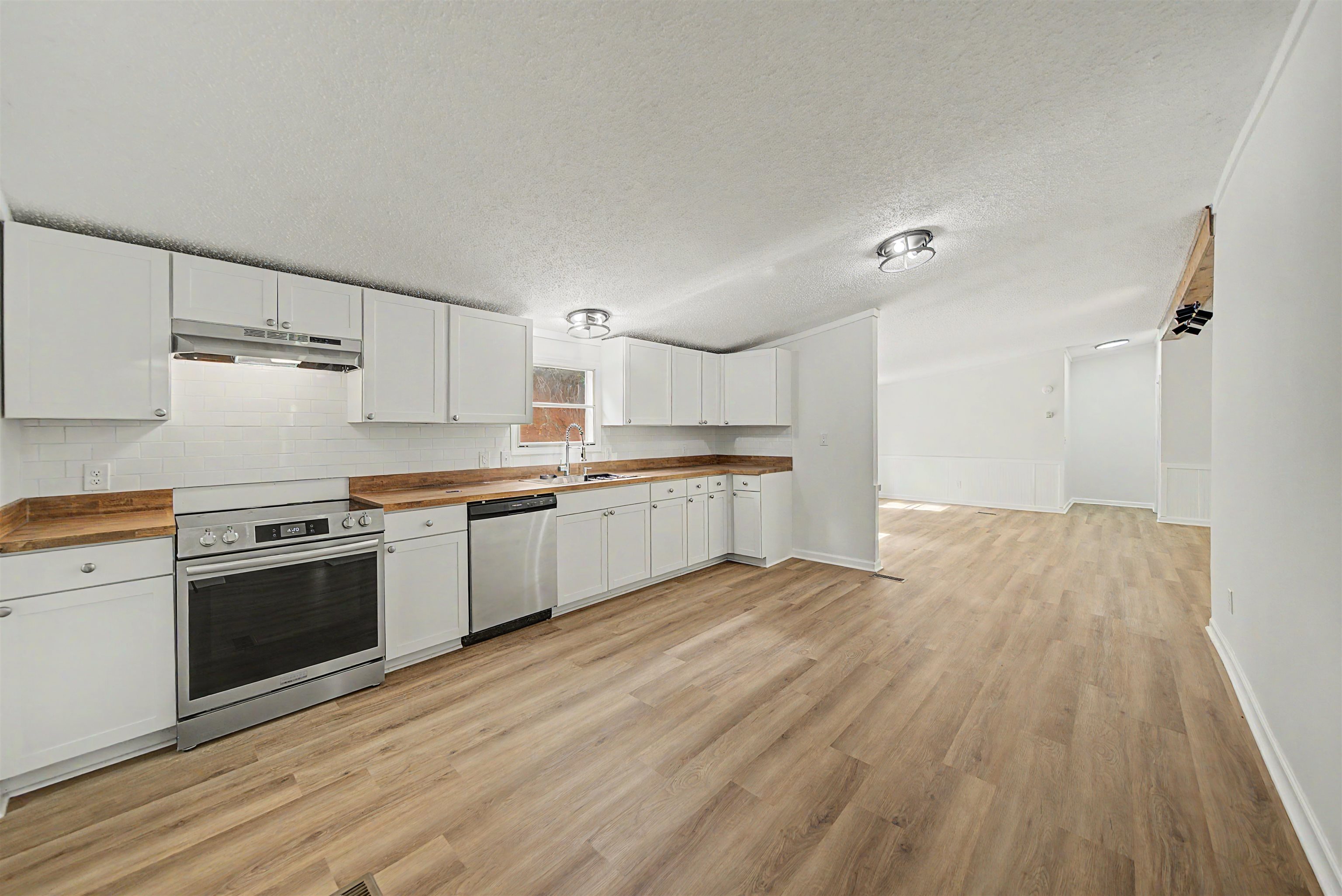 890 Burks Road Savannah, TN 38372 - Photo 7 of 40 a large kitchen with cabinets wooden floor and stainless steel appliances