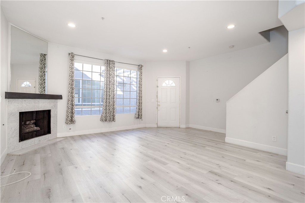 18347 Saticoy Street, Unit 28 Reseda, CA 91335 - Photo 4 of 27 a view of an empty room with a fireplace and a window