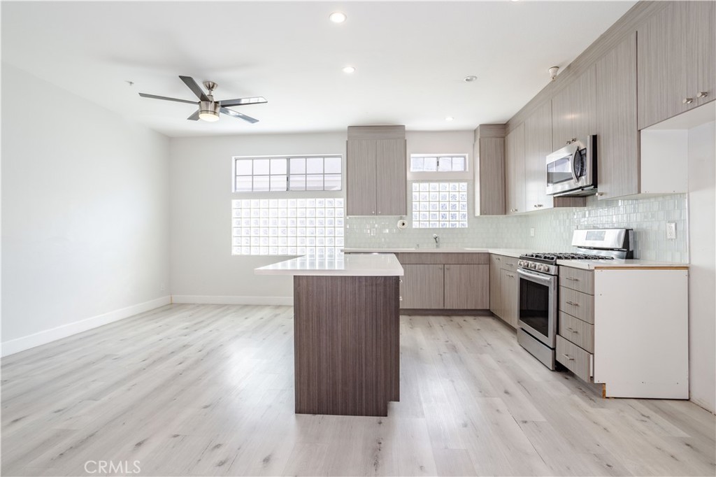18347 Saticoy Street, Unit 28 Reseda, CA 91335 - Photo 9 of 27 a kitchen with wooden floors and white appliances