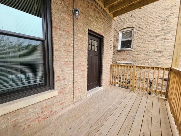a view of a brick house with wooden floor and a floor to ceiling window