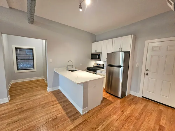 a kitchen with stainless steel appliances a refrigerator and a stove top oven