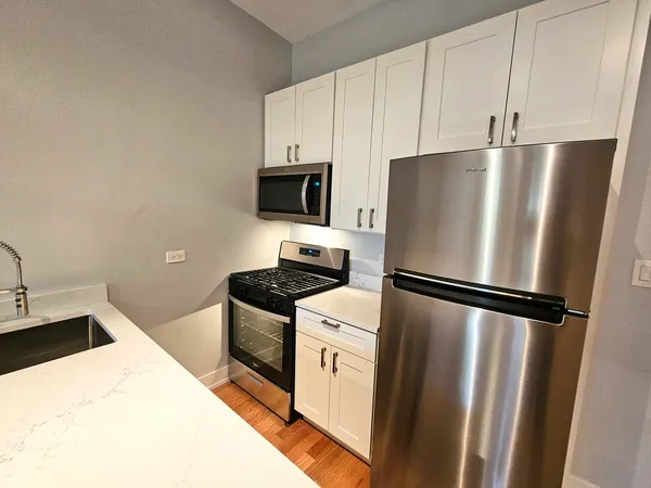 a white refrigerator freezer and a stove sitting inside of a kitchen