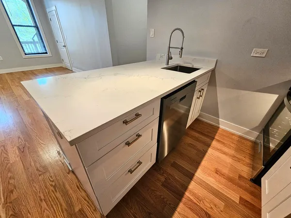 a kitchen with a sink a stove and wooden floor