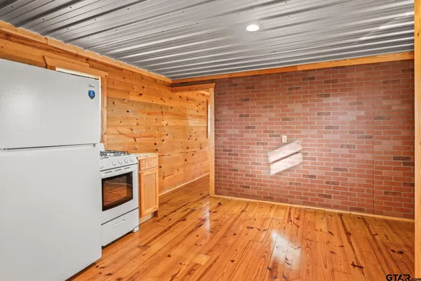 a view of empty room with a fireplace and wooden floor