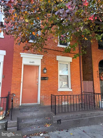 a front view of a house with a tree