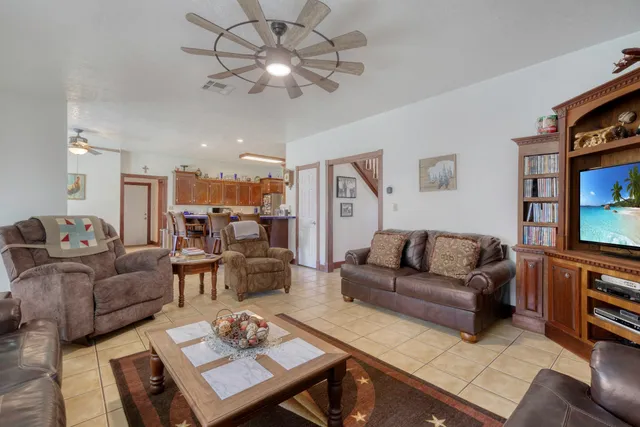 a living room with furniture kitchen view and a flat screen tv
