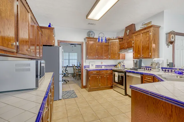 a kitchen with stainless steel appliances granite countertop a sink dishwasher stove and refrigerator