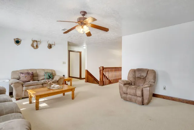 a living room with furniture and a ceiling fan