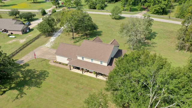 an aerial view of a house with a yard basket ball court and outdoor seating