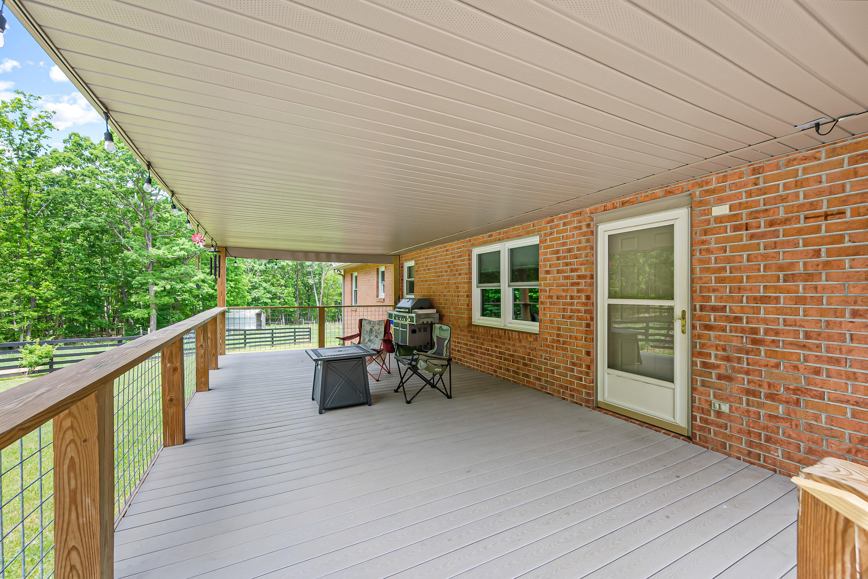1365 Brake Road Elliston, VA 24087 - Photo 67 of 98 a view of a patio with couches chairs potted plants and floor to ceiling window