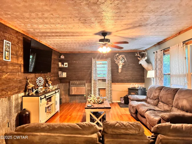 a living room with furniture a large window and a flat screen tv