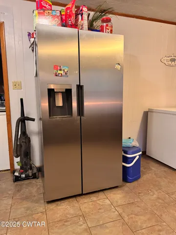 a kitchen with a refrigerator a table and chairs